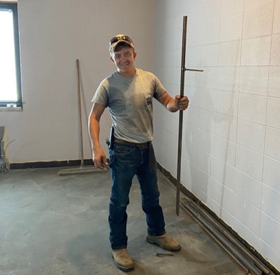 Mason poses with tools during the first week of the renovation