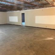 Empty cinder block wall with concrete floor and exposed ceiling
